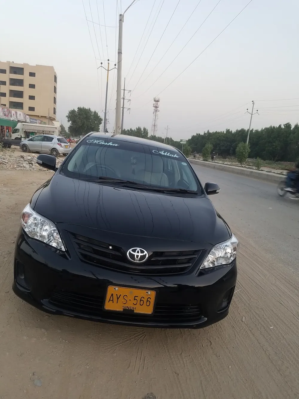 Black Toyota Corolla after paintwork, parked on the road